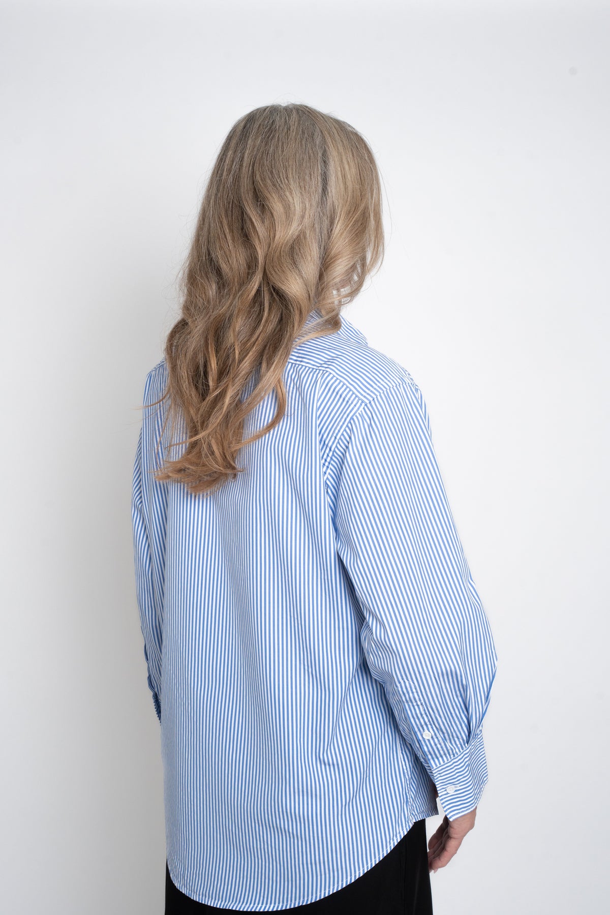 Back view of the blue-and-white striped Cyme Supima Shirt, showing its shoulder seam and curved hem.