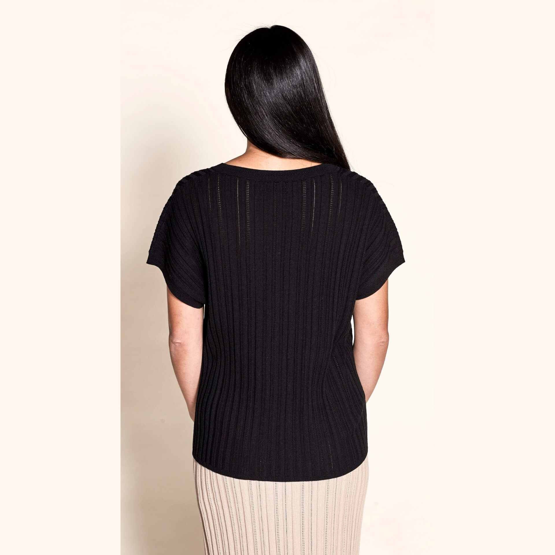 Rear view of a sleek pointelle ribbed black top by Cyme Copenhagen, highlighting the brand's focus on minimalist design and sustainable, high-quality natural fabrics in contemporary women's clothing.