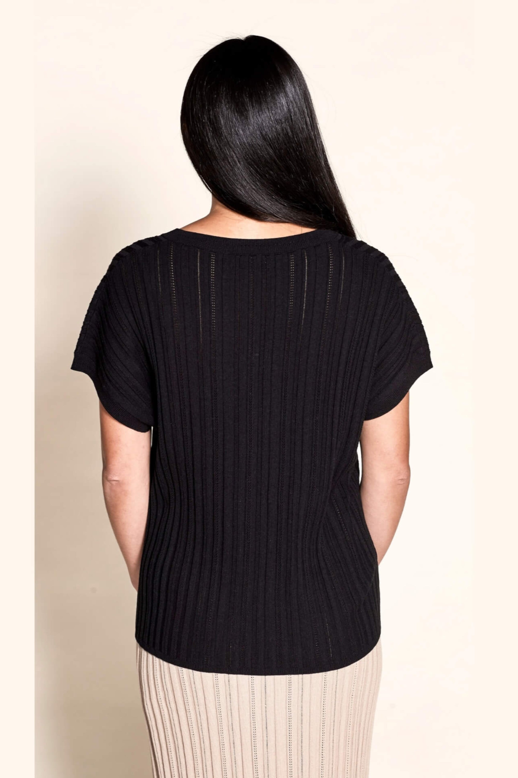 Rear view of a sleek pointelle ribbed black top by Cyme Copenhagen, highlighting the brand's focus on minimalist design and sustainable, high-quality natural fabrics in contemporary women's clothing.