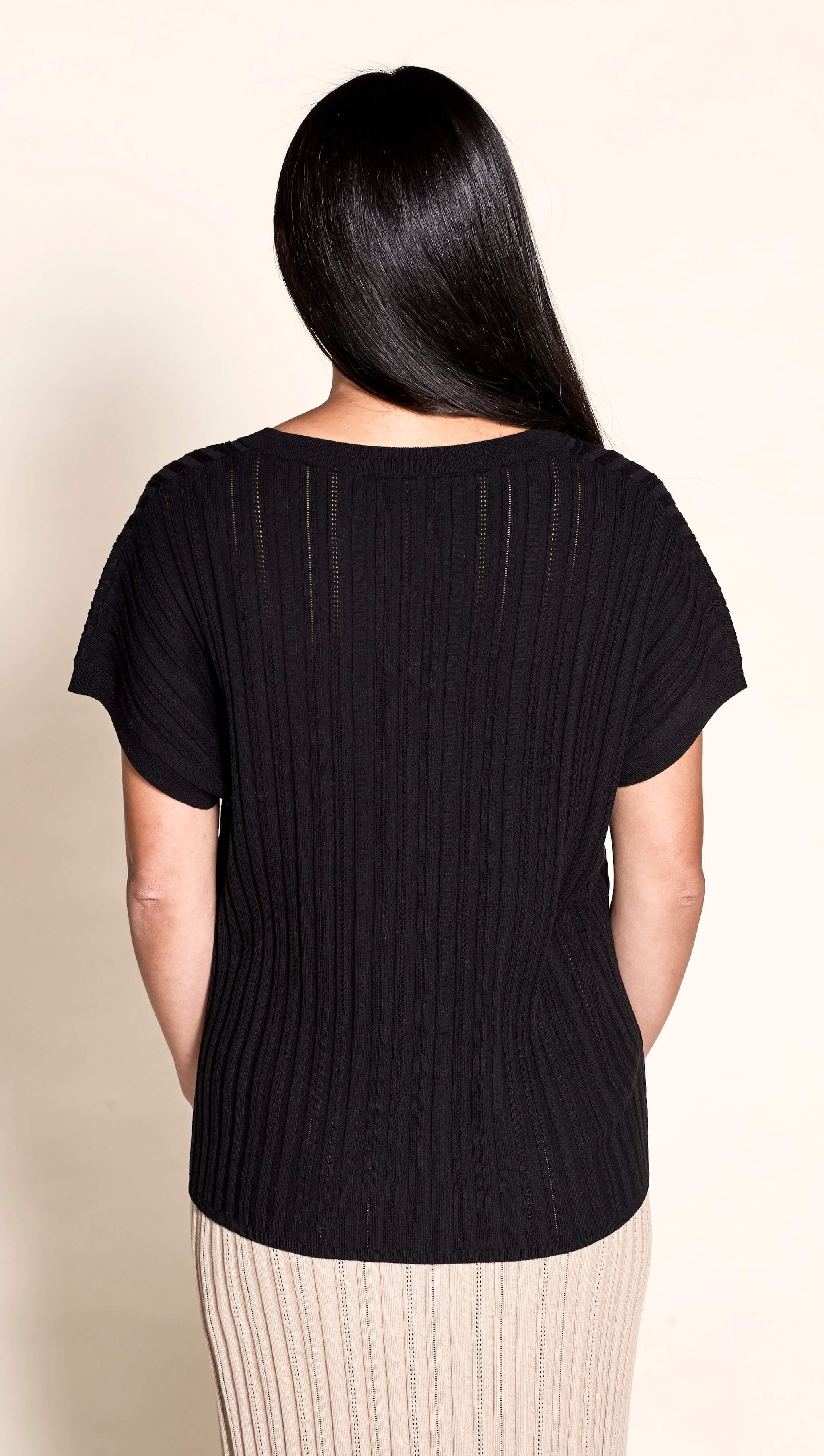 Rear view of a sleek pointelle ribbed black top by Cyme Copenhagen, highlighting the brand's focus on minimalist design and sustainable, high-quality natural fabrics in contemporary women's clothing.