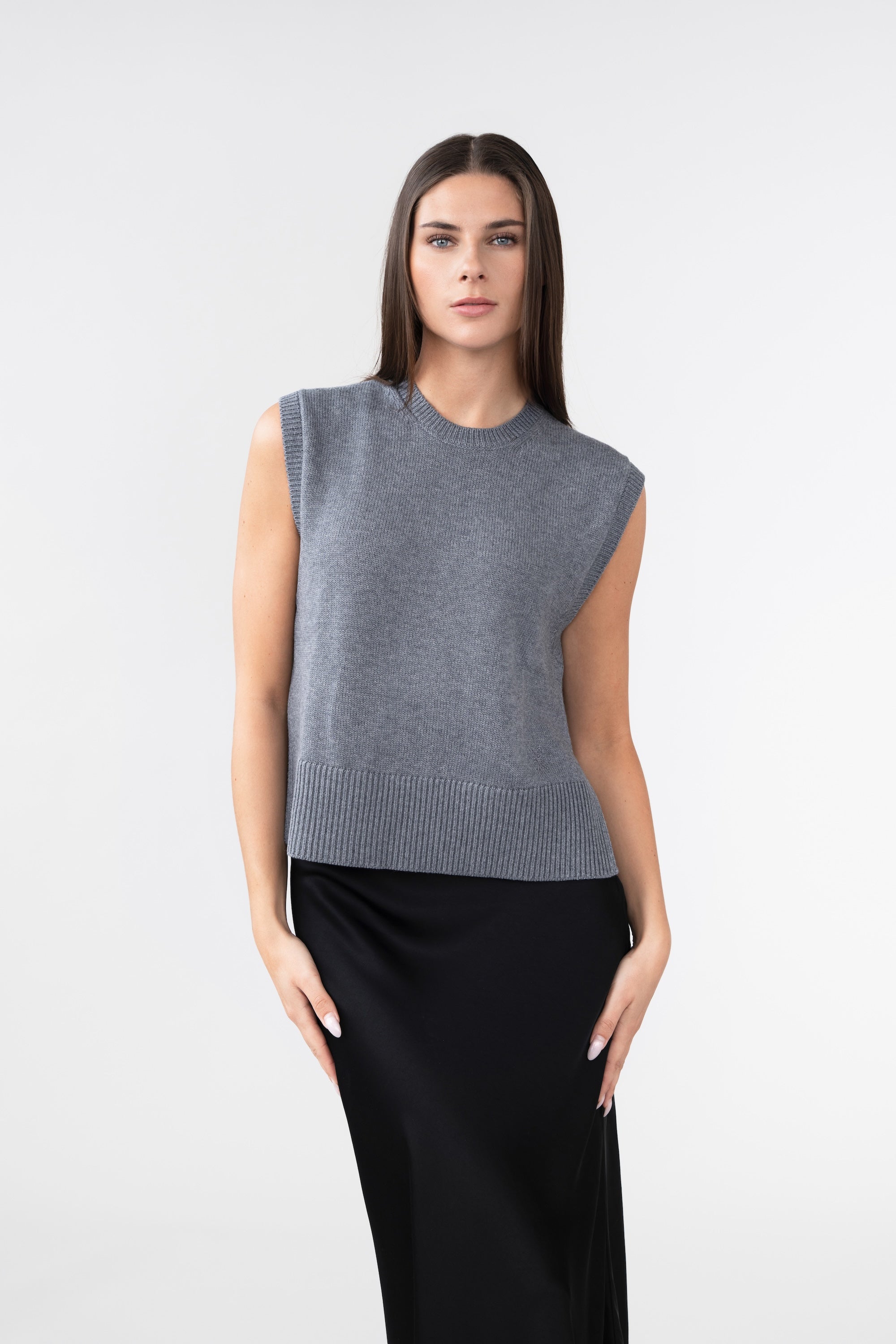 A woman wearing a grey knitted vest 