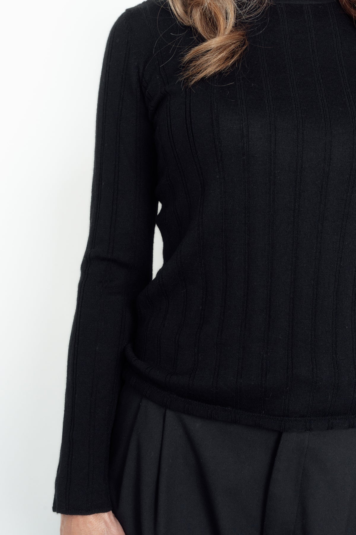 Close-up of the black Ivy Merino Top's vertical knit detailing, sleeve and hem.