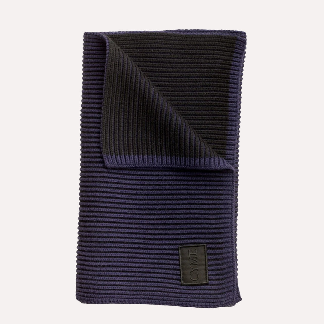 Cyme Copenhagen navy ribbed knit scarf, elegantly folded with a branded high quality patch, highlighting the brand's focus on sustainable fashion accessories in Denmark.