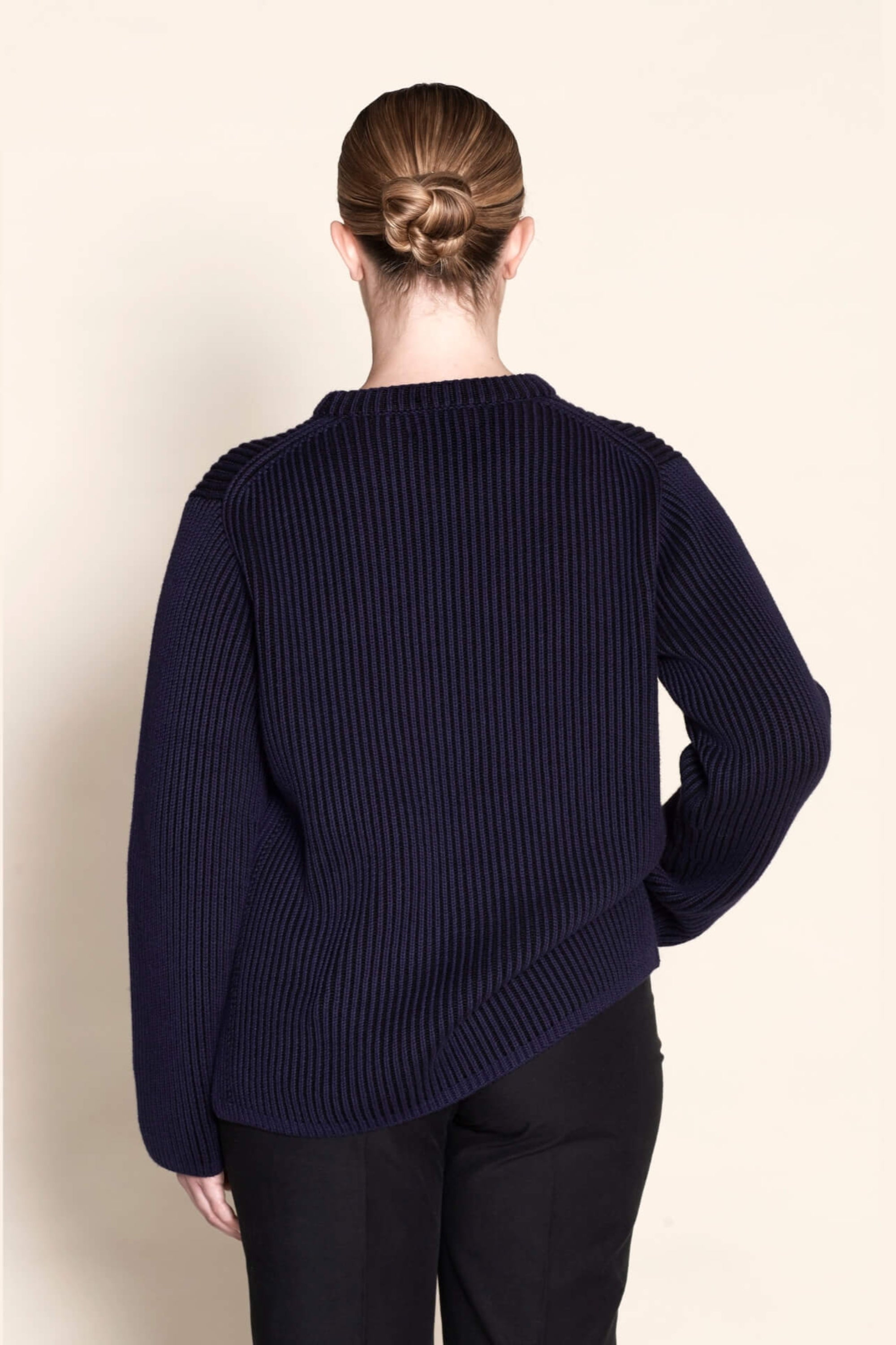 Back view of a Cyme Copenhagen navy ribbed sweater, highlighting the brand's signature knit pattern and quality craftsmanship in sustainable Danish fashion.