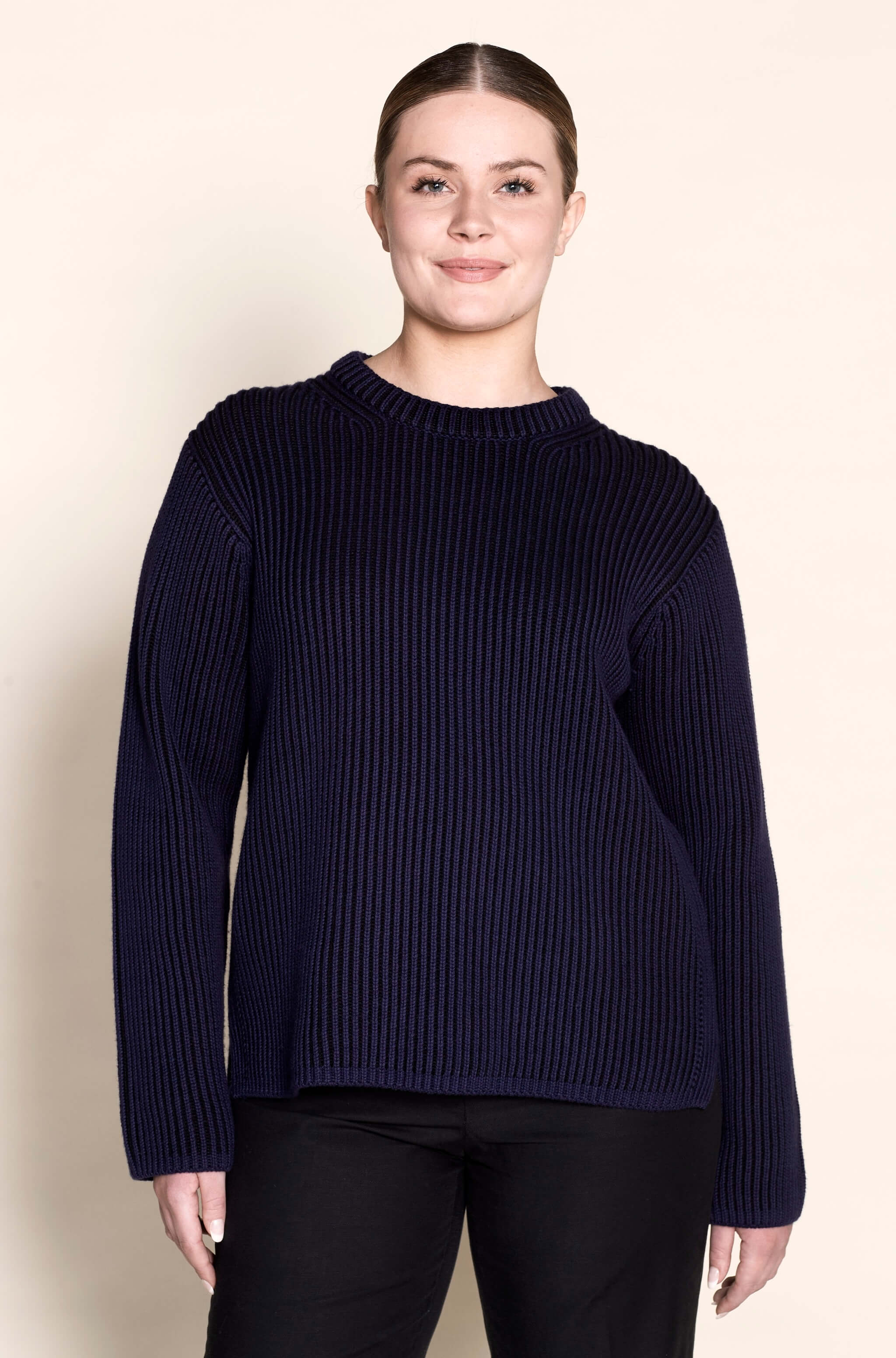Model sports a Cyme Copenhagen navy ribbed sweater, demonstrating the classic fit and sustainable materials that are hallmarks of this fashion-forward Scandinavian brand, catering to all women including plus sizes.