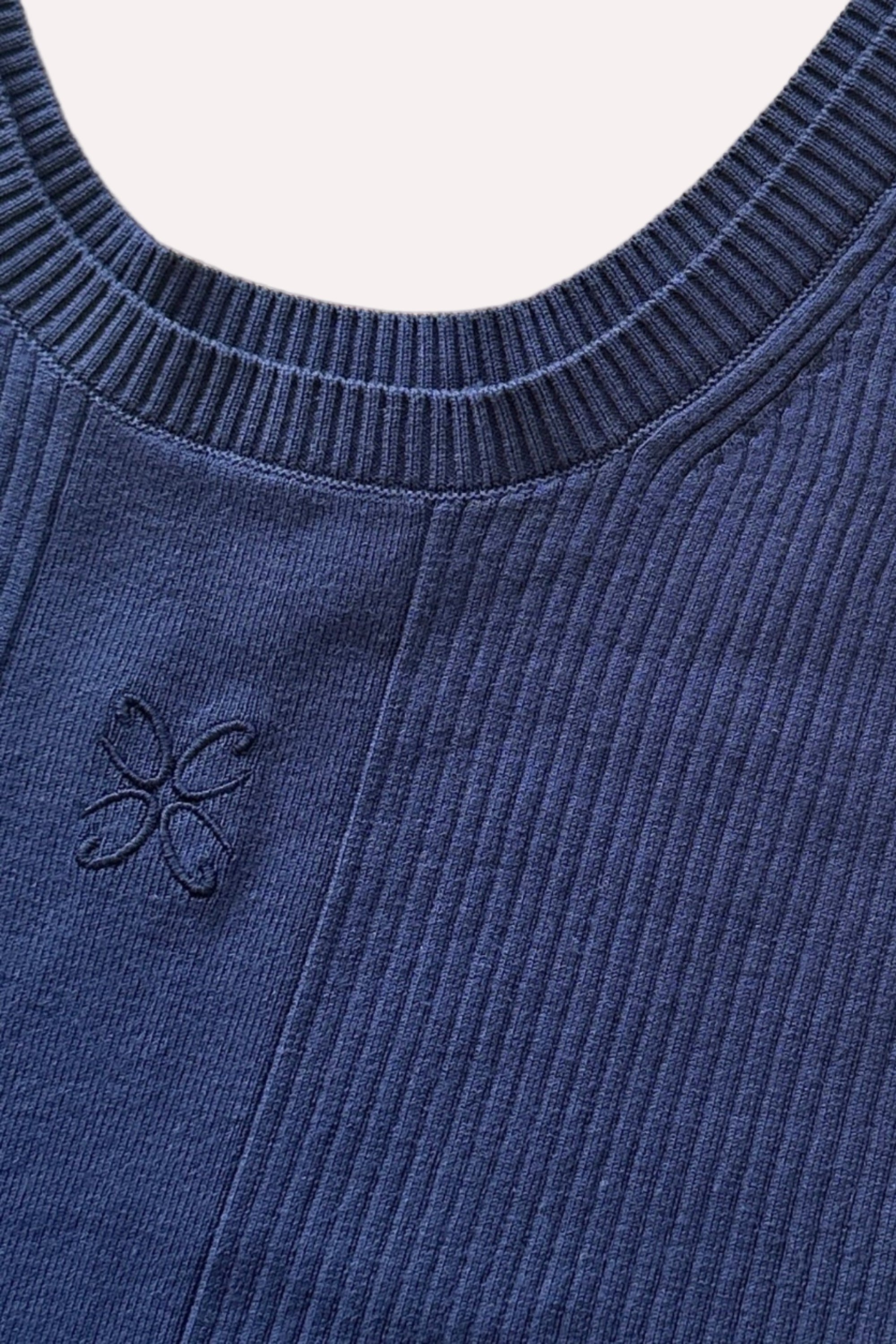 Nærbillede af ribstrikket tanktop fra CYME Copenhagen i dyb navyblå med broderet logo på brystet. Fremstillet i blød, naturlig bomuldsblanding med rund hals og brede stropper.
