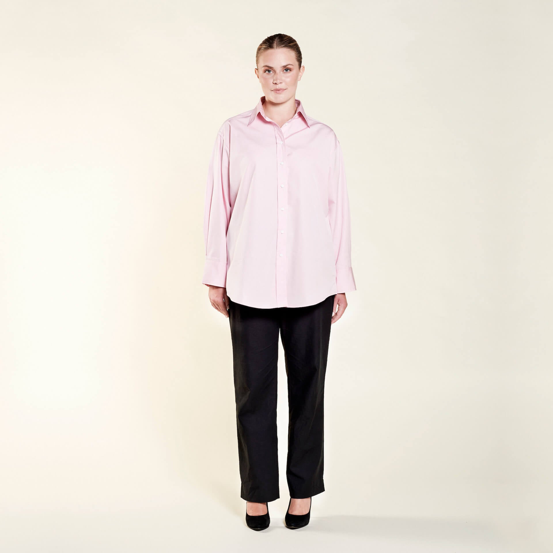 Model presenting Cyme Copenhagen's elegant oversized pink shirt, featuring a relaxed cut that combines comfort with Danish design, reflecting the brand's dedication to sustainable fashion and offering chic women's clothing for all sizes.