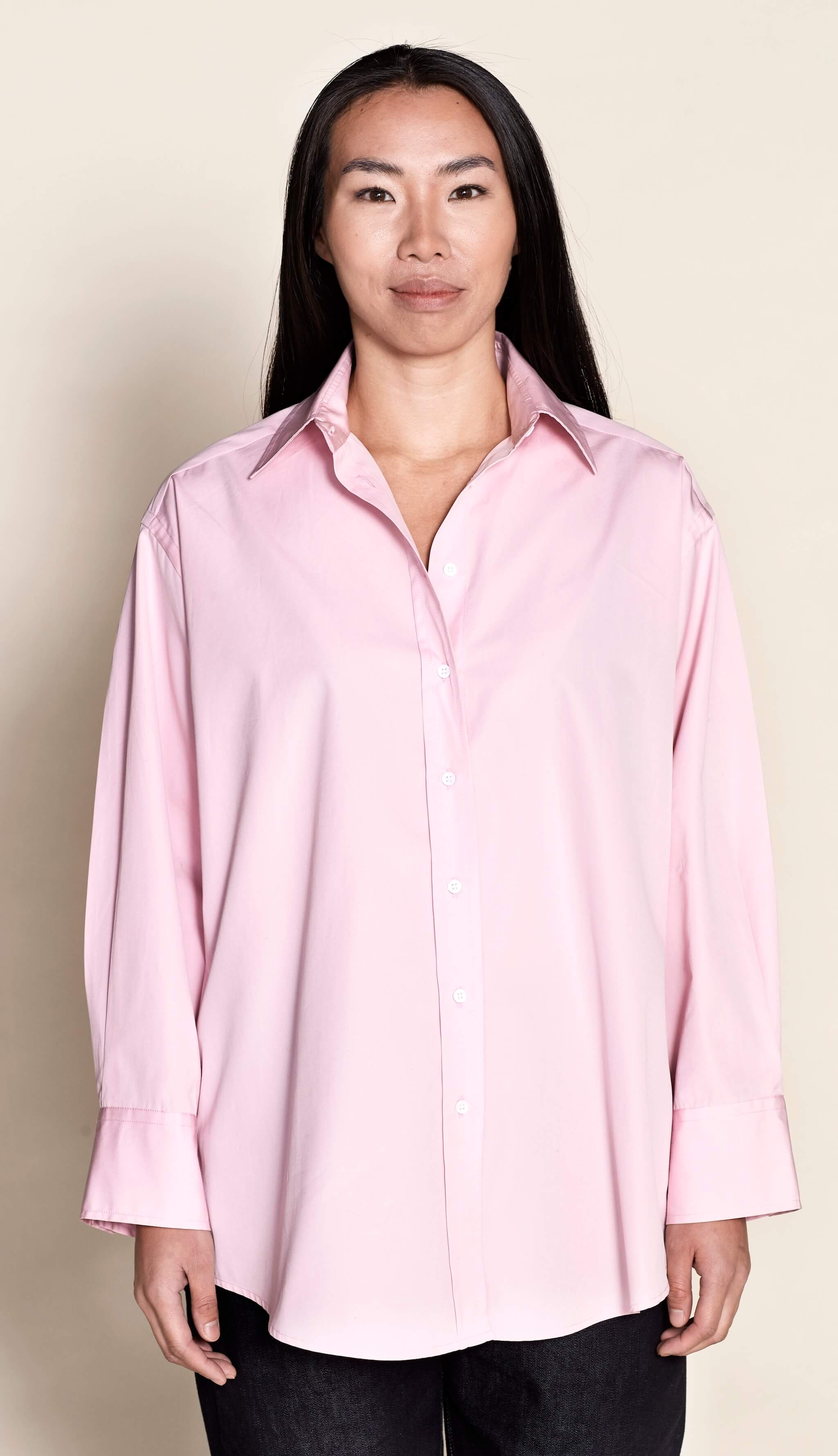 Model presenting Cyme Copenhagen's elegant oversized pink shirt, featuring a relaxed cut that combines comfort with Danish design, reflecting the brand's dedication to sustainable fashion and offering chic women's clothing for all sizes.