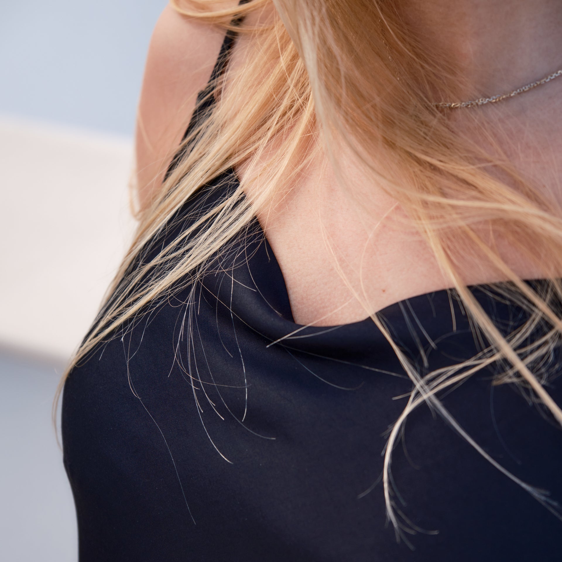Close-up of a person wearing a black top with blonde hair.