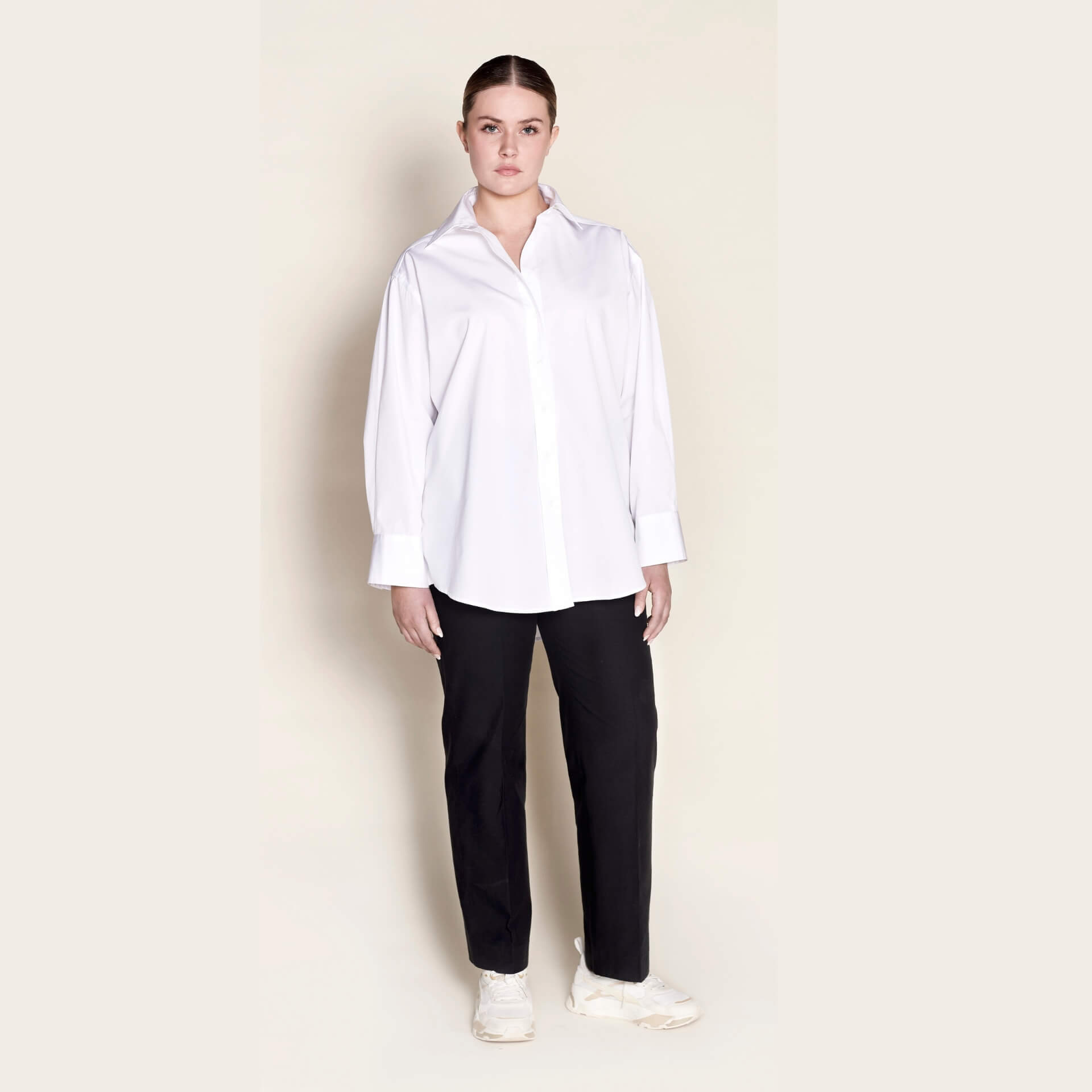 Model in a Cyme Copenhagen classic white button-up shirt paired with black trousers, showcasing a crisp, professional look that captures the essence of Scandinavian minimalist design.