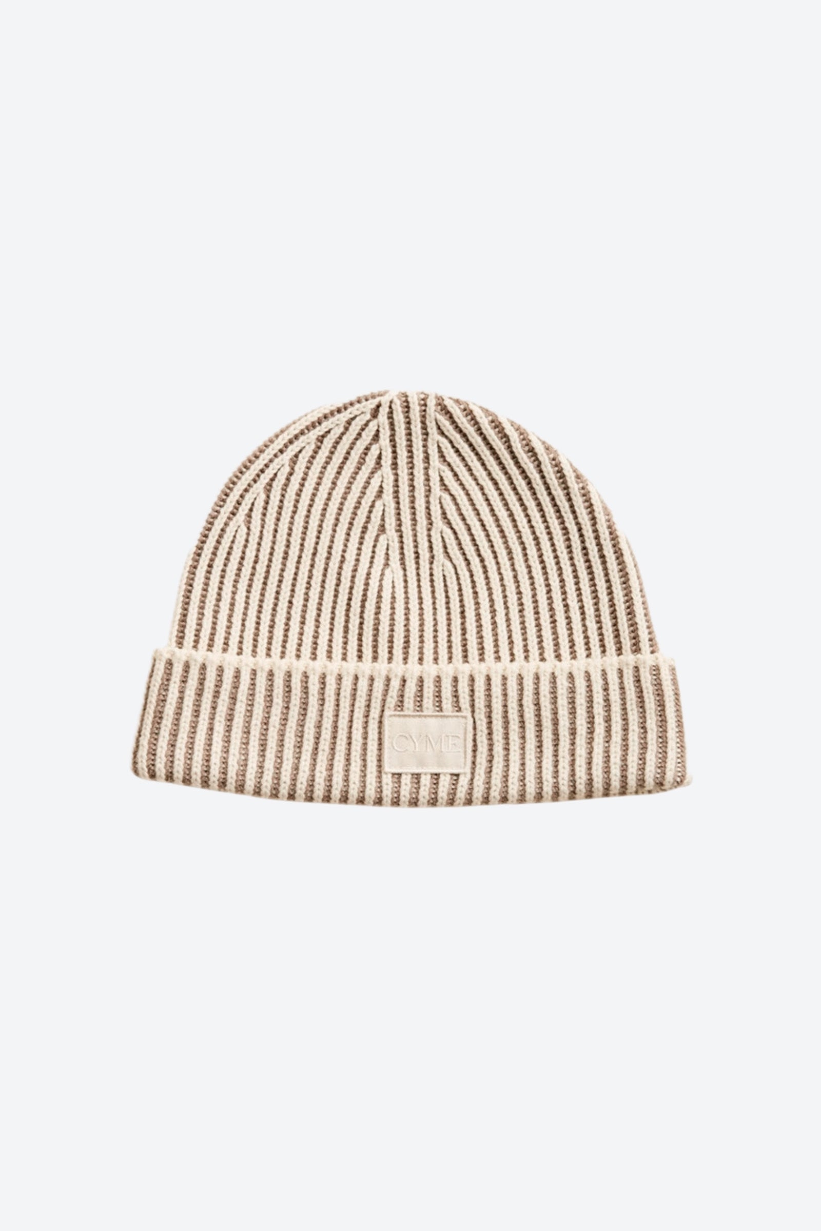 Close-up of Cyme Copenhagen's luxurious cashmere beanie in neutral tones, featuring the brand's logo, a testament to Scandinavian quality and timeless design in sustainable fashion.