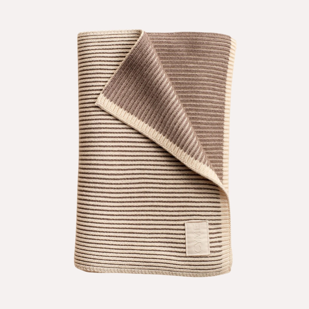 Premium cashmere scarf featuring neutral stripes, elegantly unfolded to showcase the Cyme Copenhagen logo, reflecting the brand’s commitment to natural materials and Scandinavian timeless design.