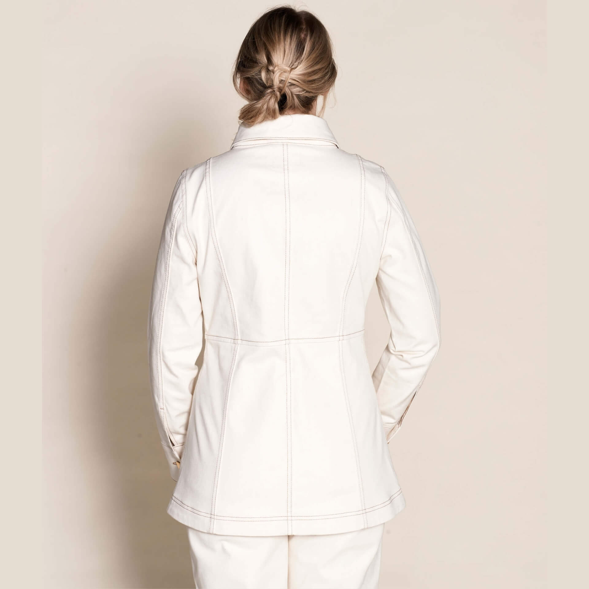 Rear view of a woman wearing Cyme Copenhagen's tailored cream denim jacket, exemplifying the brand's sleek Danish design and commitment to sustainable materials in fashion-forward women's clothing.