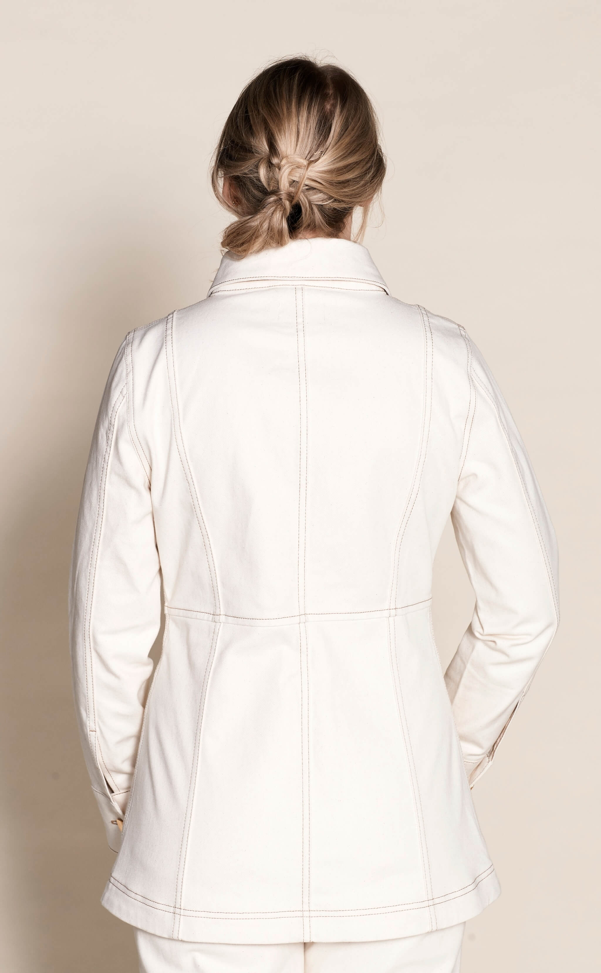 Rear view of a woman wearing Cyme Copenhagen's tailored cream denim jacket, exemplifying the brand's sleek Danish design and commitment to sustainable materials in fashion-forward women's clothing.